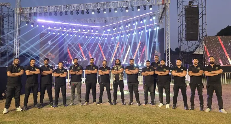 GHS team lined up in front of an illuminated event stage