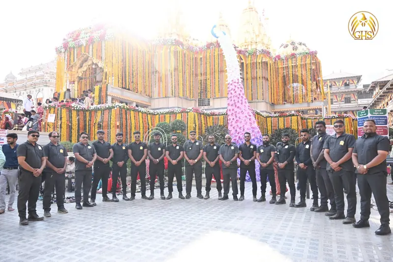 A long line of Golden Hawk Security guards at a flower-decorated festival venue