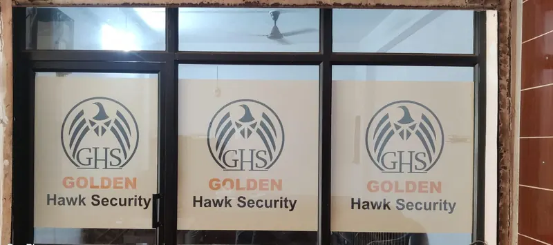 Golden Hawk Security logo on frosted glass panels at the company office
